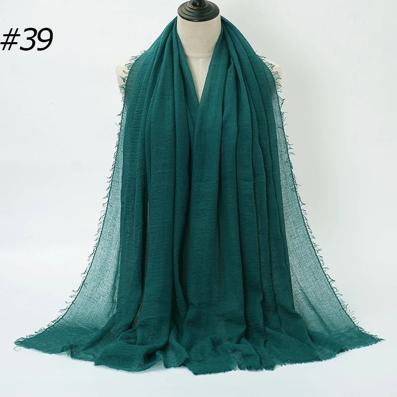 Dunkel-türkis-crinkliges Baumwoll-Hijab-Schal um einen Mannequin-Hals drapiert.