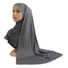 Une femme modèle un foulard en jersey de coton gris élégant avec des accents de diamants drapé sur sa tête et ses épaules.