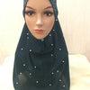 Pañuelo de hijab musulmán de cuentas color verde azulado oscuro usado por una modelo.