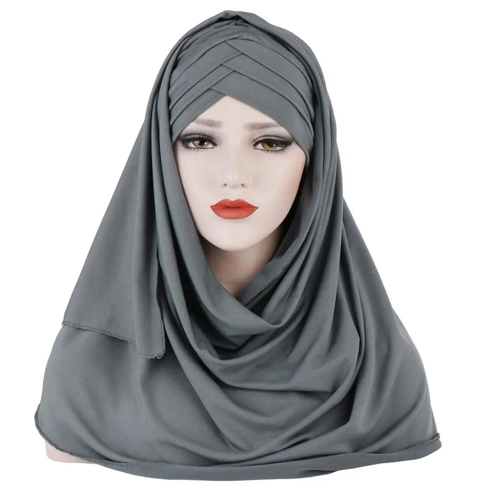 Un foulard châle en jersey de coton doux gris drapé sur la tête et les épaules d'une femme.