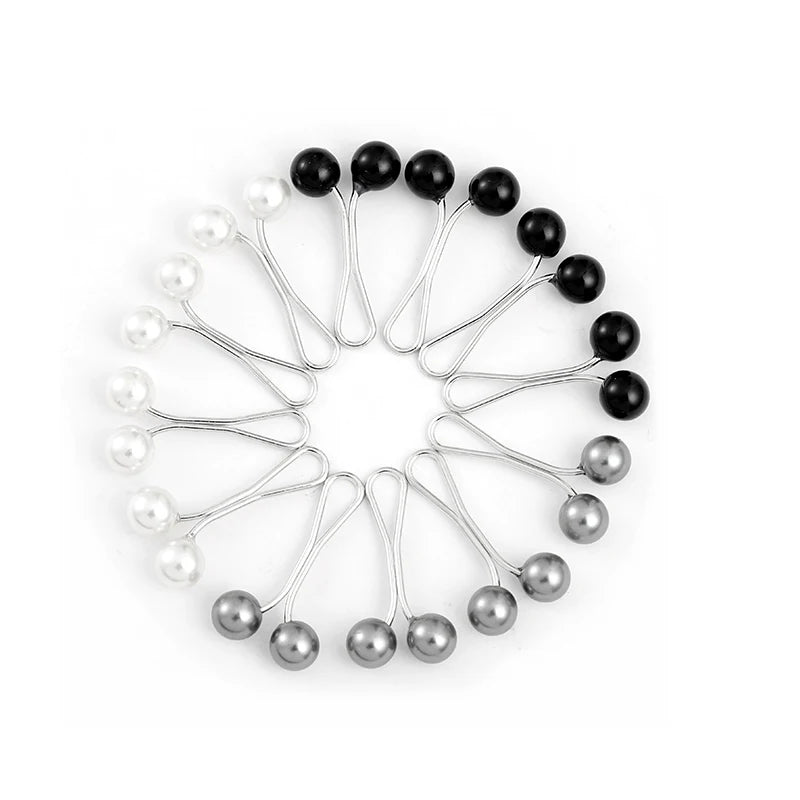 A circular arrangement of twelve black and white pearl brooch headscarf pins.
