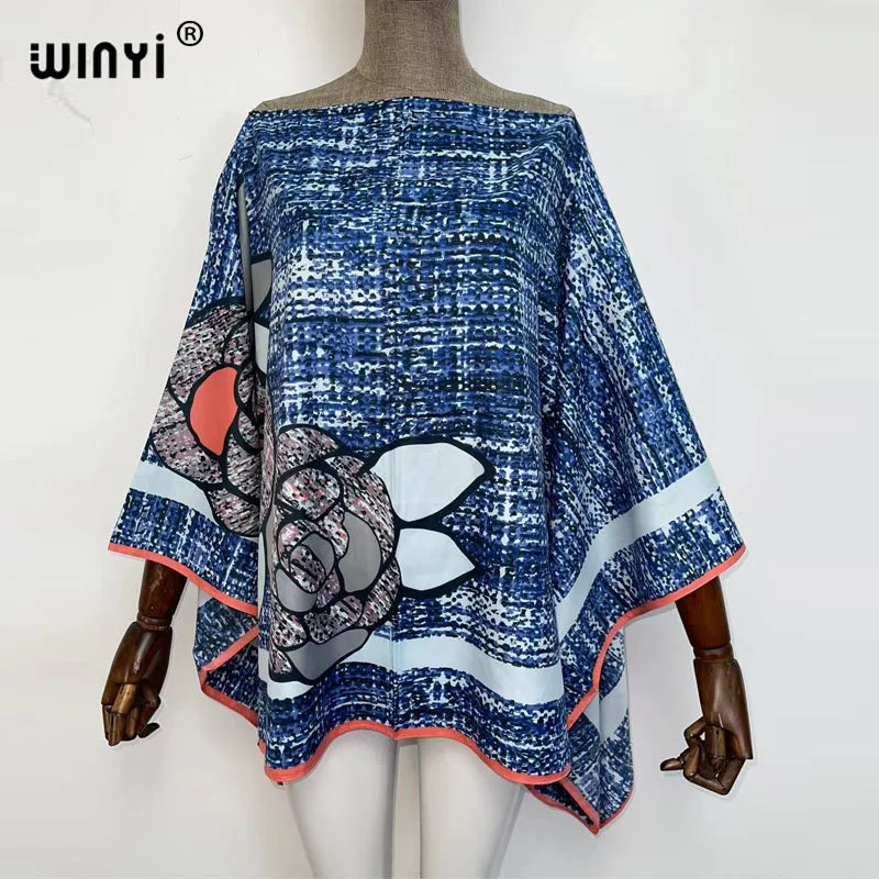 A blue and white patterned batwing abaya top displayed on a mannequin.