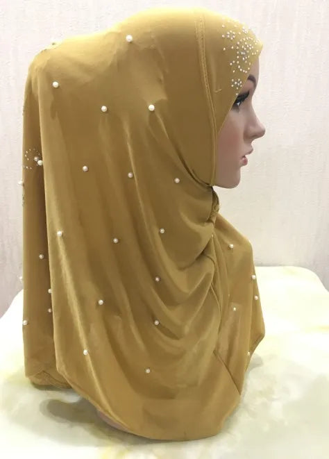 Pañuelo de hijab hecho a mano de cuentas amarillo mostaza drapeado sobre la cabeza de un maniquí.