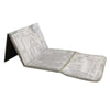 A foldable Islamic prayer rug in a light gray color, shown folded and unfolded.