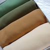 Eine Stapel von vier schlichten Chiffon-Hijabs oder Instant-Schals in Olivgrün, Beige und Tan, von der Seite betrachtet.