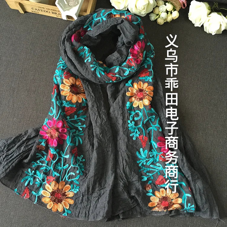 Dunkelgrabesäuberliches, besticktes Wintertuch mit leuchtend pinken, orangen und türkisen Blumen.