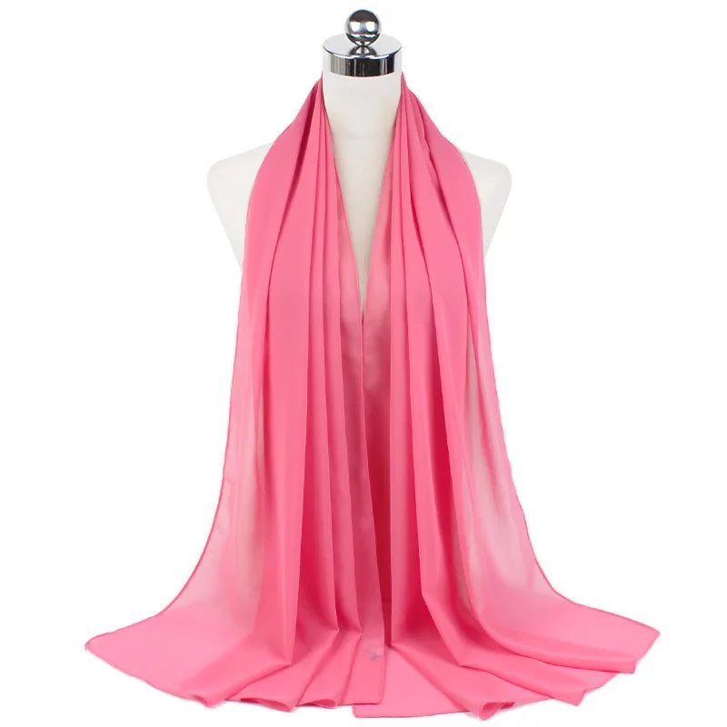 Un pañuelo de chifón rosa brillante drapeado alrededor del cuello de un maniquí.
