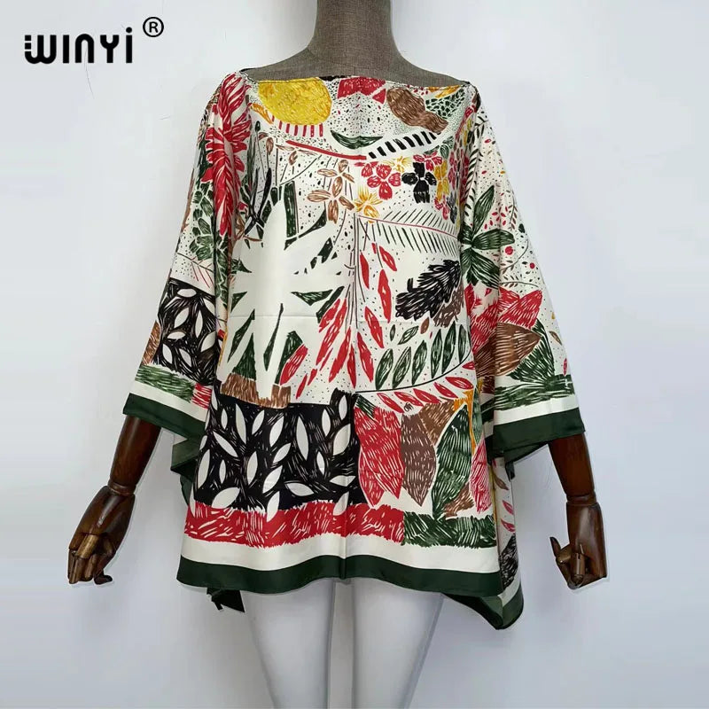 A women's bohemian summer batwing abaya top featuring a colorful floral and leaf print in earthy tones.