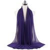 Un pañuelo de chifón morado drapeado alrededor del cuello de un maniquí.