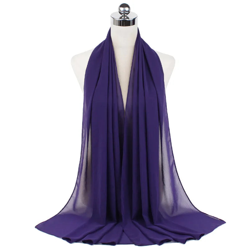 Un pañuelo de chifón morado drapeado alrededor del cuello de un maniquí.