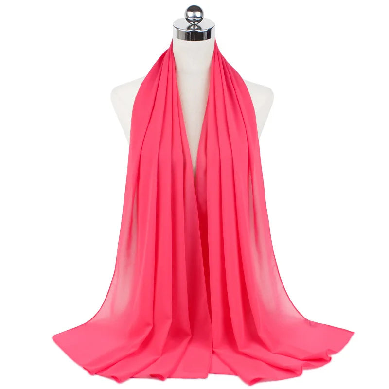 Un pañuelo de chifón rosa brillante drapeado alrededor del cuello de un maniquí.