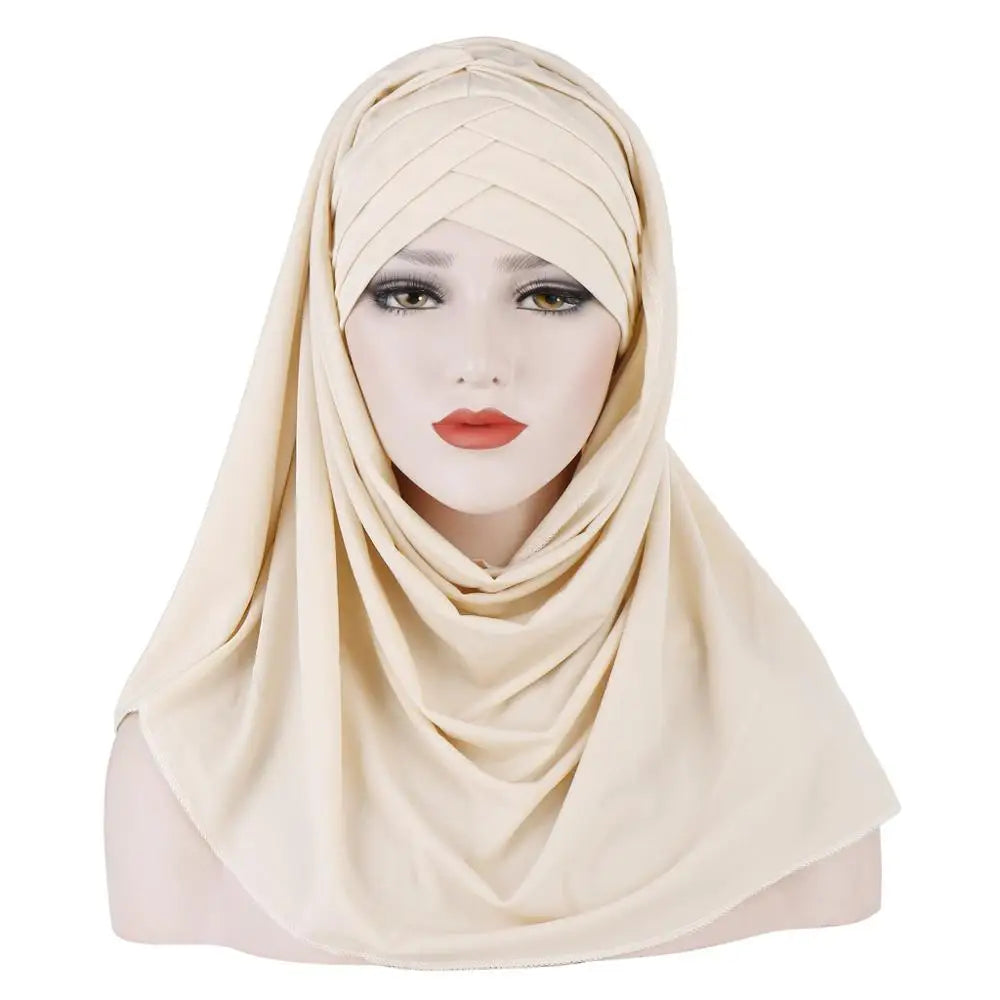 Une femme modèle un châle hijab en jersey de coton beige autour de sa tête et de son cou.