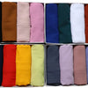 Eine Sammlung gefalteter, einfacher Chiffon-Hijabs in verschiedenen einfarbigen Farben wie Schwarz, Braun, Pink, Blau, Grün, 