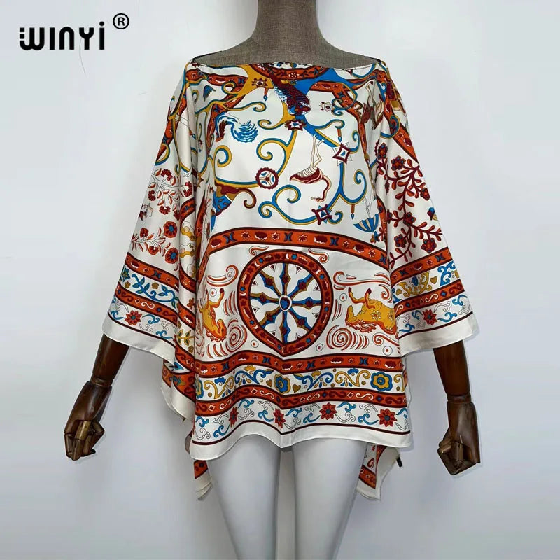 A woman wearing a colorful bohemian summer batwing abaya top with intricate patterns.