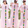 Eine Frau modelliert ein rosa Kaftan-Set mit farbenfroher geometrischer Stickerei auf dem Vorderteil und den Ärmeln.