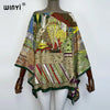 A model is wearing a colorful bohemian summer batwing abaya top featuring intricate patterns and earthy tones.