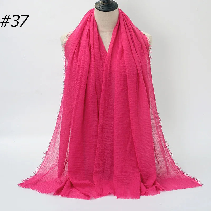 Leuchtend pinker Crinkle-Baumwoll-Hijab-Schal, um den Hals eines Mannequins drapiert.