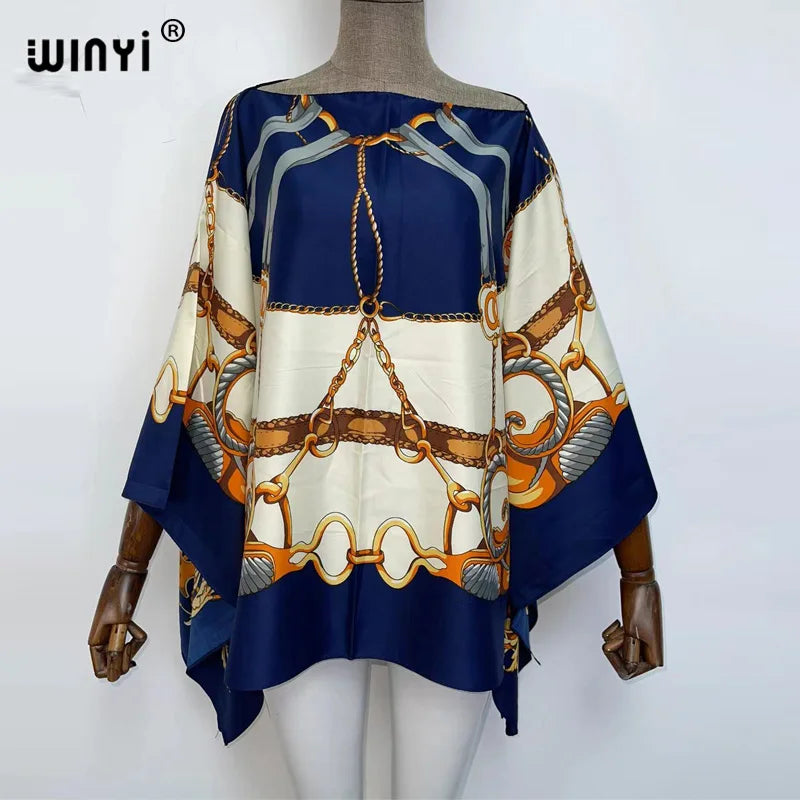 A women's blue and cream batwing abaya top featuring intricate gold chain detailing.