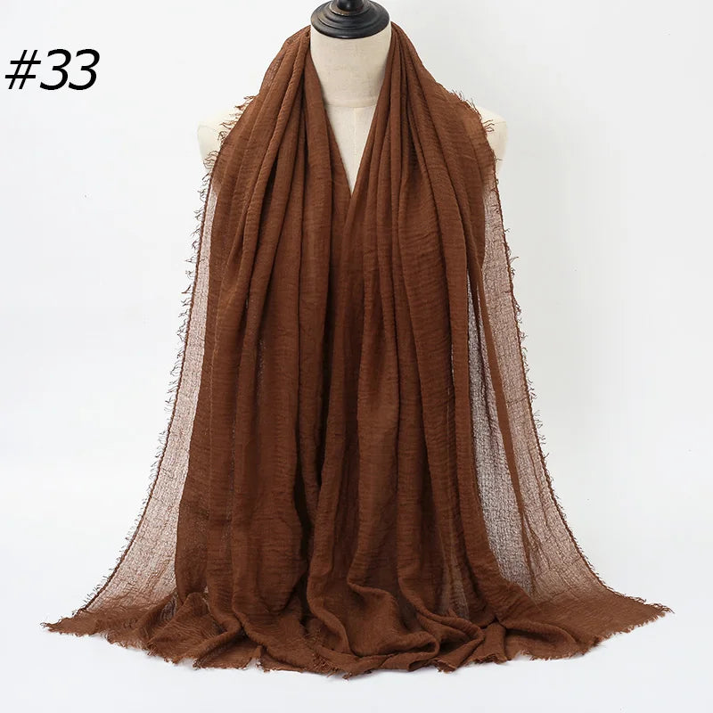 Brauner gekräuselter Baumwoll-Hijabschal über einem Mannequin drapiert.