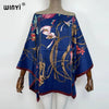 A dark blue batwing abaya top featuring floral embroidery and flowing fabric displayed on a mannequin.