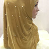 Pañuelo de hijab bordado con cuentas amarillo mostaza drapeado sobre un maniquí.