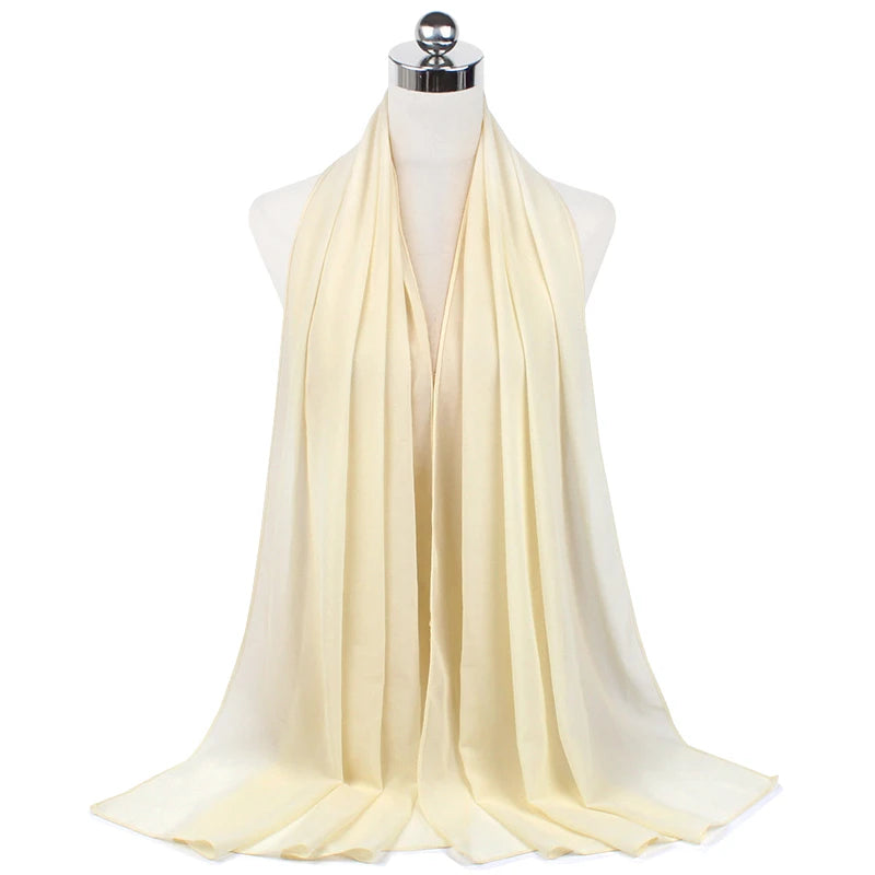 Pañuelo de chifón color crema drapeado alrededor del cuello de un maniquí.
