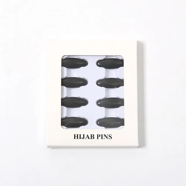Eine weiße Karte mit mehreren schwarzen Hijab-Pins.