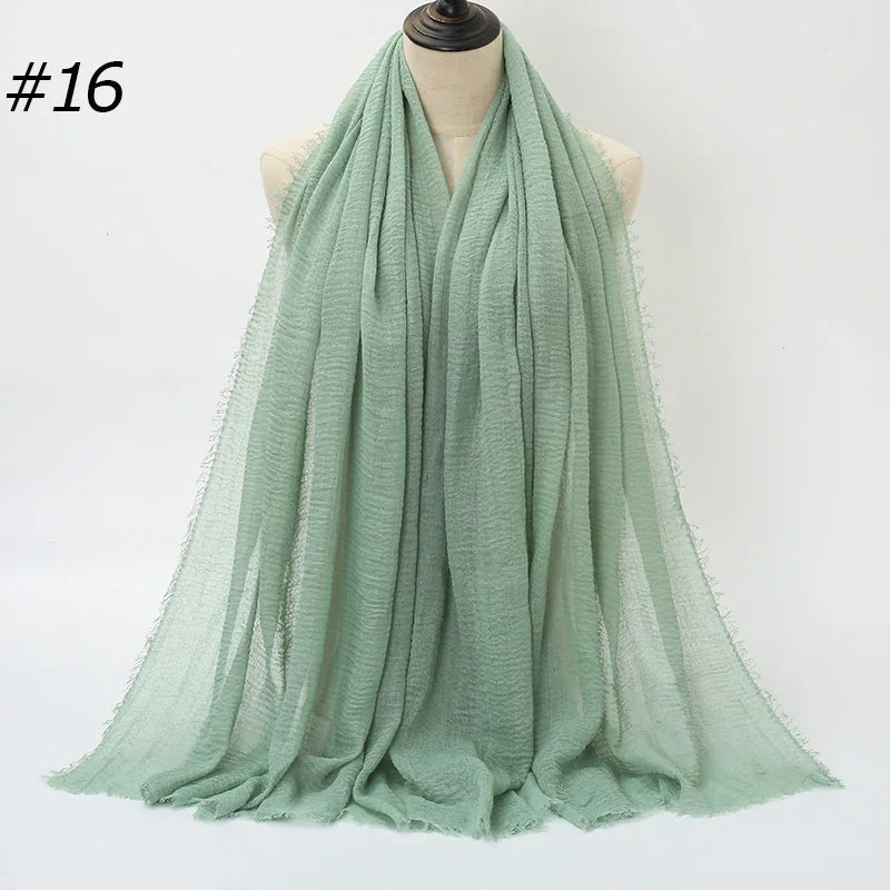 Helles mintgrünes Crinkle-Baumwoll-Hijab-Schal, um den Hals eines Mannequins gewickelt.