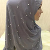Pañuelo de hijab bordado gris hecho a mano drapeado en la cabeza de un maniquí.