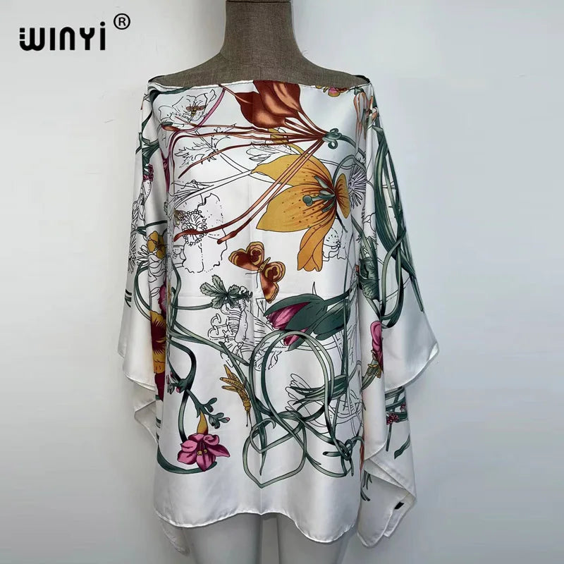 White batwing abaya top featuring a floral and vine pattern with shades of green, orange, and pink.