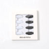 Una caja rectangular blanca que contiene ocho sujetadores y pinzas para pañuelos (hijabs) en blanco y negro.
