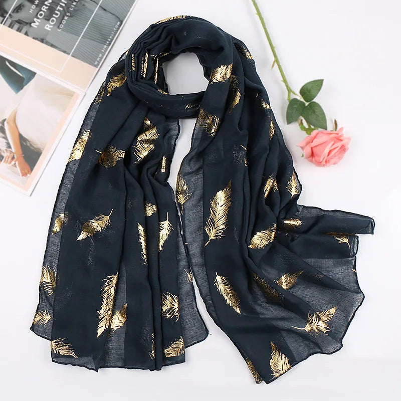 Dunkelblaue Seid وشal mit goldenen Federdrucken elegant drapiert auf weißem Hintergrund.