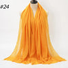 Orange crinkled cotton hijab scarf draped around a mannequin neck