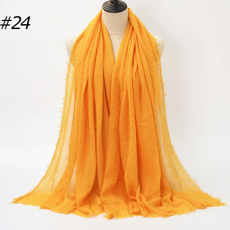 Orange crinkled cotton hijab scarf draped around a mannequin neck