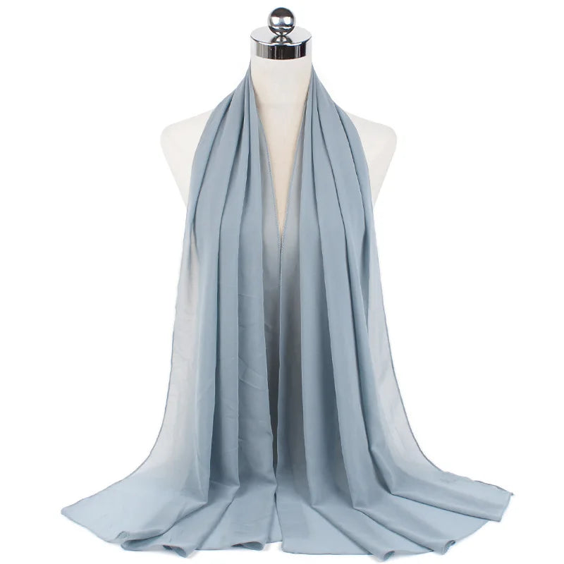 Un pañuelo de chifón azul claro drapeado alrededor del cuello de un maniquí.