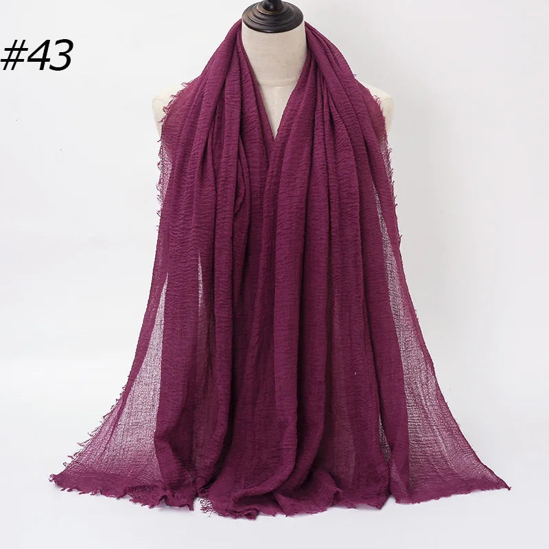 Ein tiefmagentaer gerüschter Baumwoll-Hijab-Schal, um den Hals eines Mannequins drapiert.