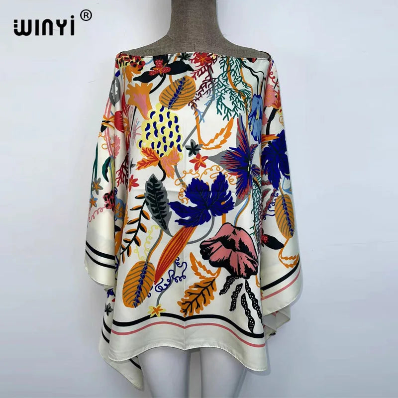A women's bohemian summer batwing abaya top featuring a colorful floral and leaf print on a light background.