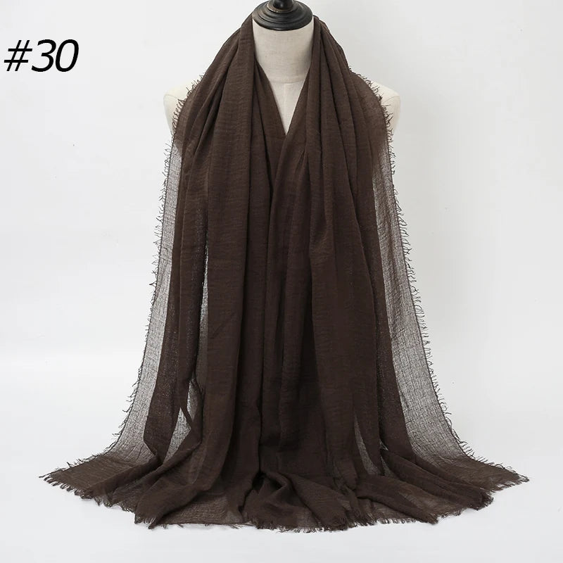 Dunkelbraischer gekräuselter Baumwoll-Hijabschal über einem Mannequin drapiert.