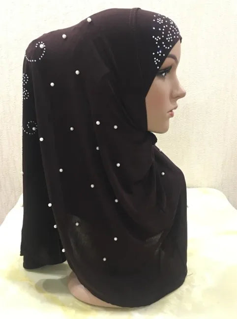 Bufanda de hijab musulmana con cuentas marrón oscuro exhibida en maniquí.