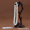 Black agate prayer beads on a stand with a white tassel necklace
