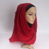 Eine Mannequin zeigt einen einfachen roten Baumwoll-Hijab-Schal, der über Kopf und Hals drapiert ist.