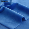 Nahaufnahme von weichem blauem Samtstoff, gefaltet und drapiert auf einem hellblauen Hintergrund.