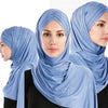 Une femme portant un foulard de châle en jersey de coton bleu clair