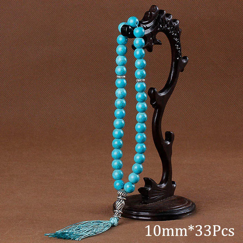 Black agate prayer beads on a stand with a turquoise tassel necklace