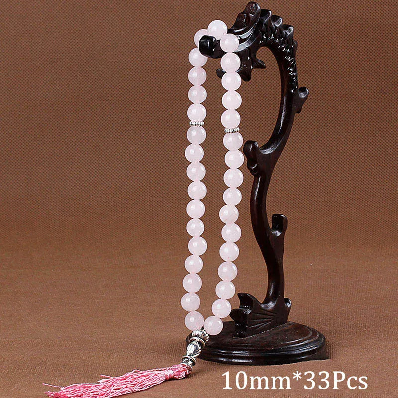 Black agate prayer beads on a stand with a pink tassel necklace
