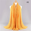 Helles orange gestreiftes Baumwoll-Hijab-Schal, der auf einem Mannequin drapiert ist.