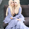 Zwei Frauen tragen elegante, solide Chiffon-Hijabs in Beige- und Lilatönen und sitzen zusammen.