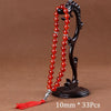 Black agate prayer beads on a stand with a red tassel necklace