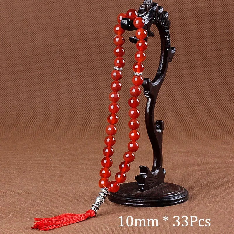 Black agate prayer beads on a stand with a red tassel necklace