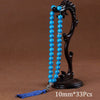 Black agate prayer beads on a stand with a blue tassel necklace